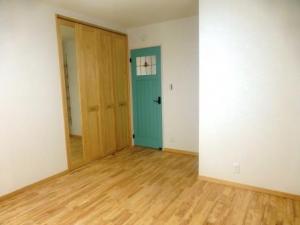 ブルーのドアがさわやかな洋室　床はラバーウッド